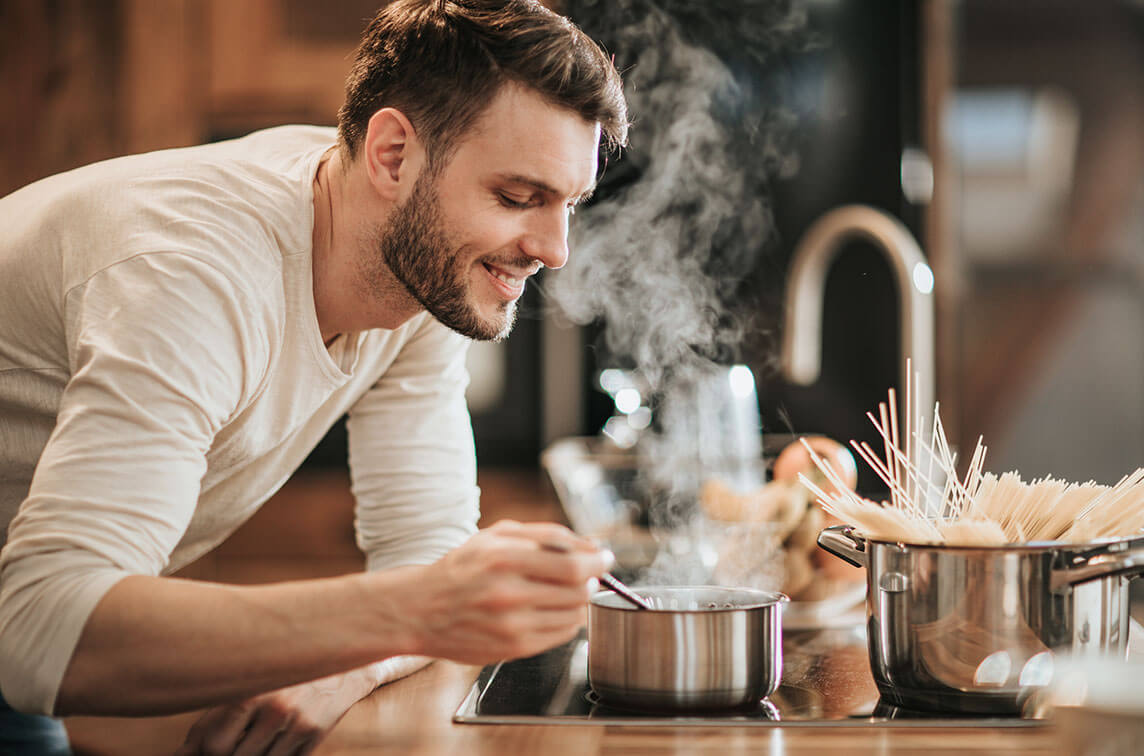 Photo of a happy man cooking with whole-home filtered water