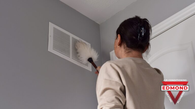 Homeowner checking an air vent before the fall heating season