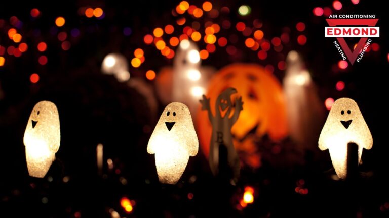 Glowing ghost and pumpkin decorations surrounded by colorful Halloween lights at night